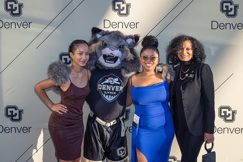 CU Denver students Bria Combs and Savannah Brooks pose with Milo and Regent Wanda James.