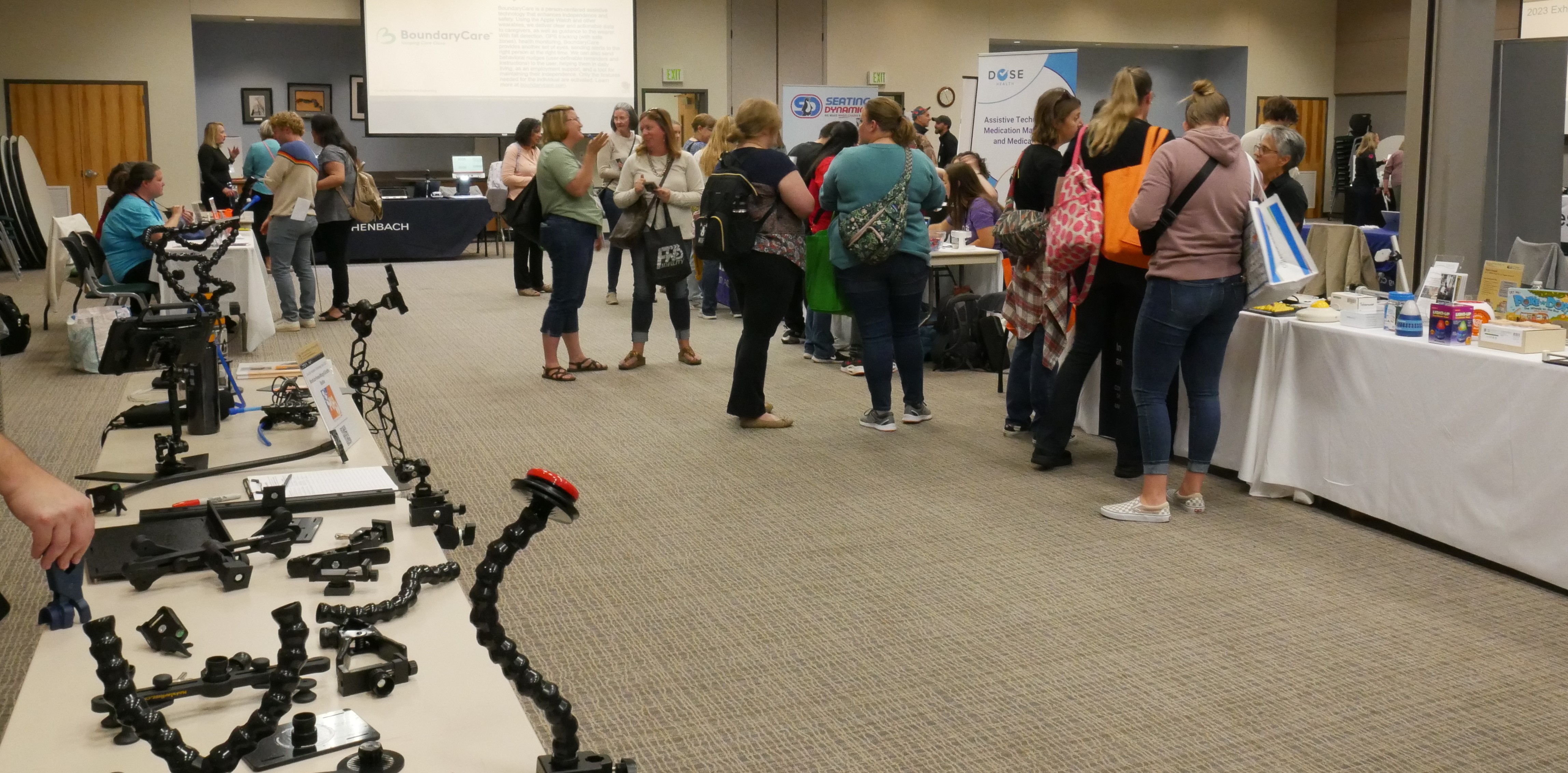 Modular hose mounts cover a table, people mill about the AT Expo beyond