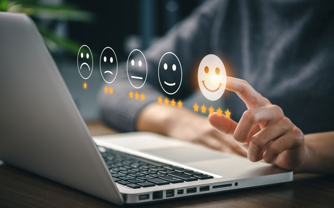 Graphic of a laptop and someone selecting a happy face for a positive user experience.