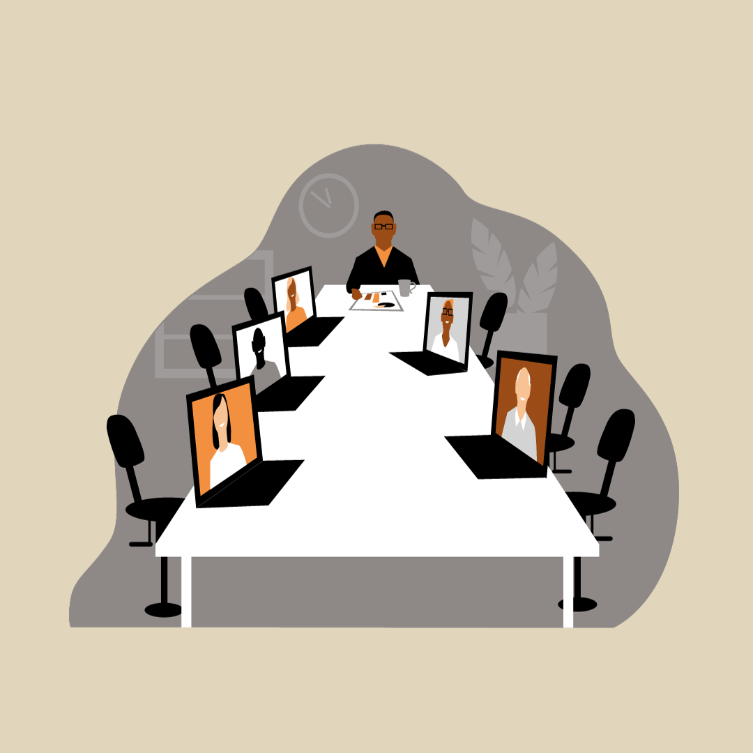 Person at a table with laptops for a hybrid conference